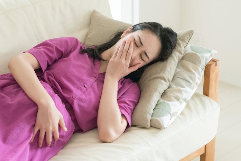 Một người mẹ trẻ đang kiểm tra thông tin dinh dưỡng trên ly trà sữa phượng hoàng, thể hiện sự lo lắng về an toàn sức khỏe và dinh dưỡng cho bản thân và em bé.